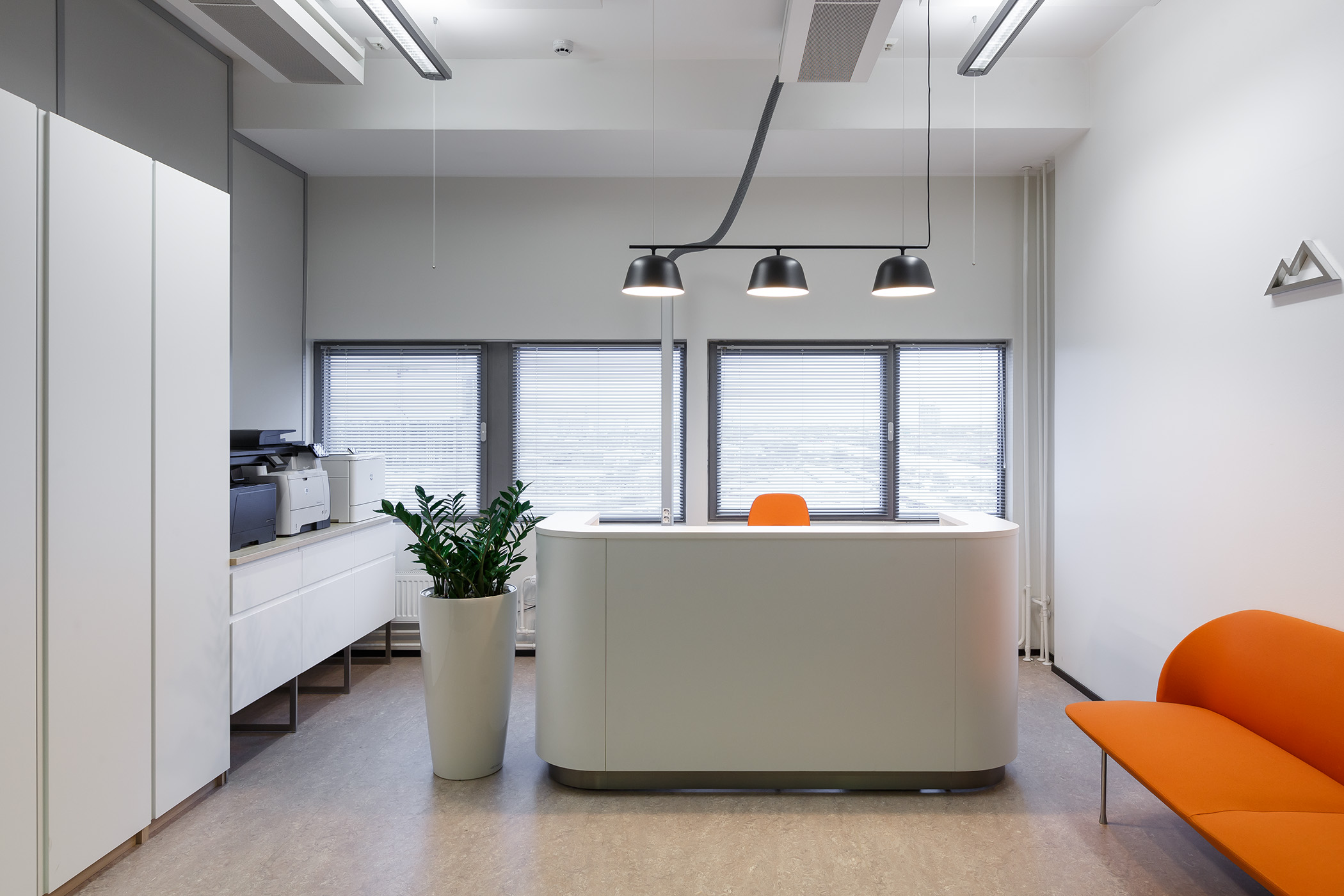 Над стойкой ресепшн в офисе Sever Minerals разместили локальное освещение, чтобы сотруднику было комфортно работать Над стойкой ресепшн в офисе Sever Minerals разместили локальное освещение, чтобы сотруднику было комфортно работать